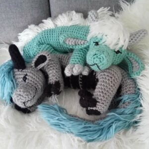 Photograph featuring two crochet dragon plushies, handmade by Sophie's Art Creations. Photo de deux peluches dragon au crochet, fait main par Sophie's Art Creations.